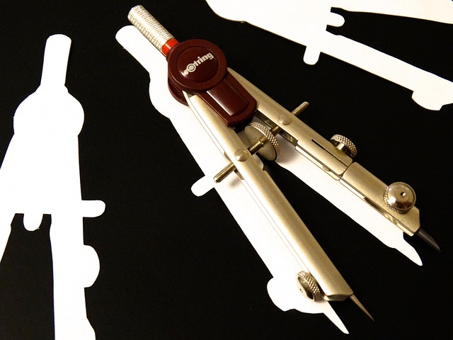 A compass placed on a contrasting black background with white silhouettes of tools.